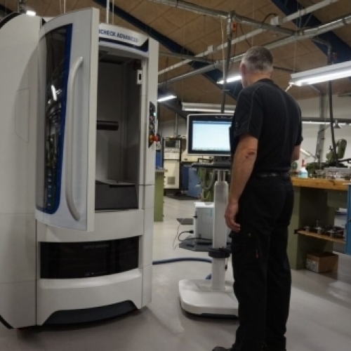 Operatør overvåger CNC-slibemaskine til professionel værktøjsslibning i moderne sliberi.